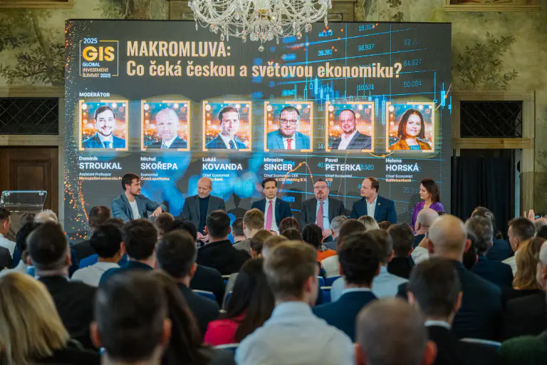 Wide panel discussion with a large branded stage screen