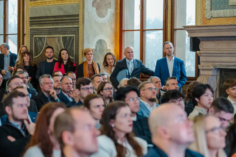 Attentive delegates seated in an ornate historic hall
