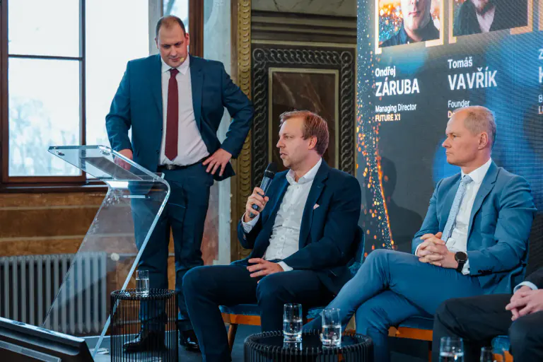 Speakers in discussion on a conference stage