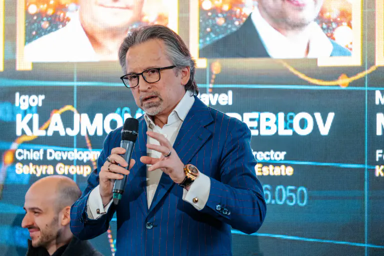 Speaker presenting in front of a large event screen
