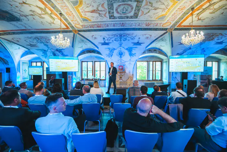 Conference audience and screen integrated into a decorated historic hall
