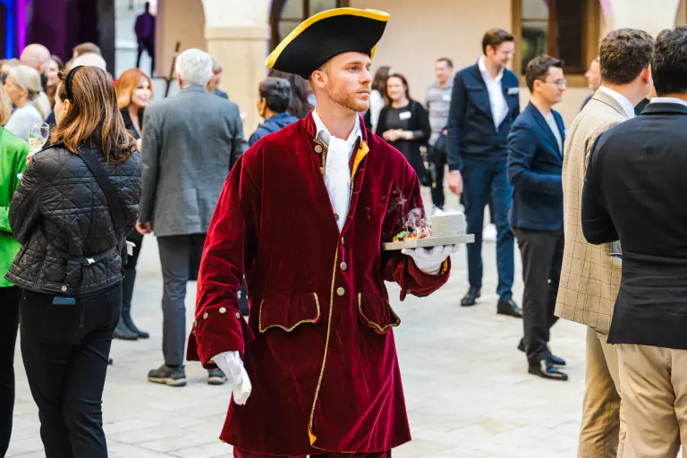Costumed host serving guests during an outdoor Prague reception