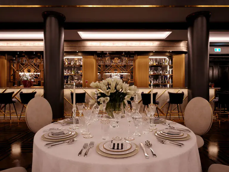 Illuminated bar and floral dining table inside Empire Hall