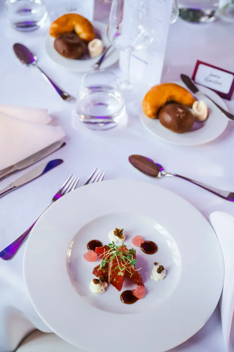 Plated first course presented on a formal dinner table