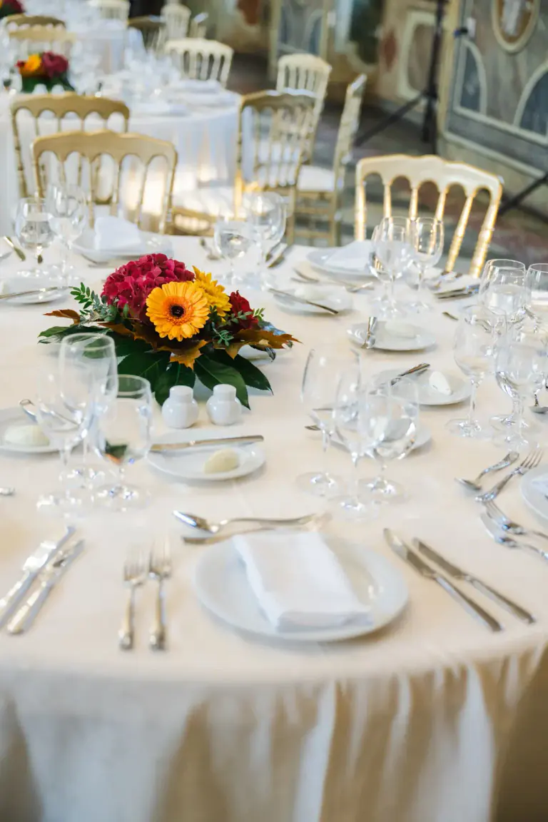 Formal table setting with glassware, folded napkins and a floral centrepiece