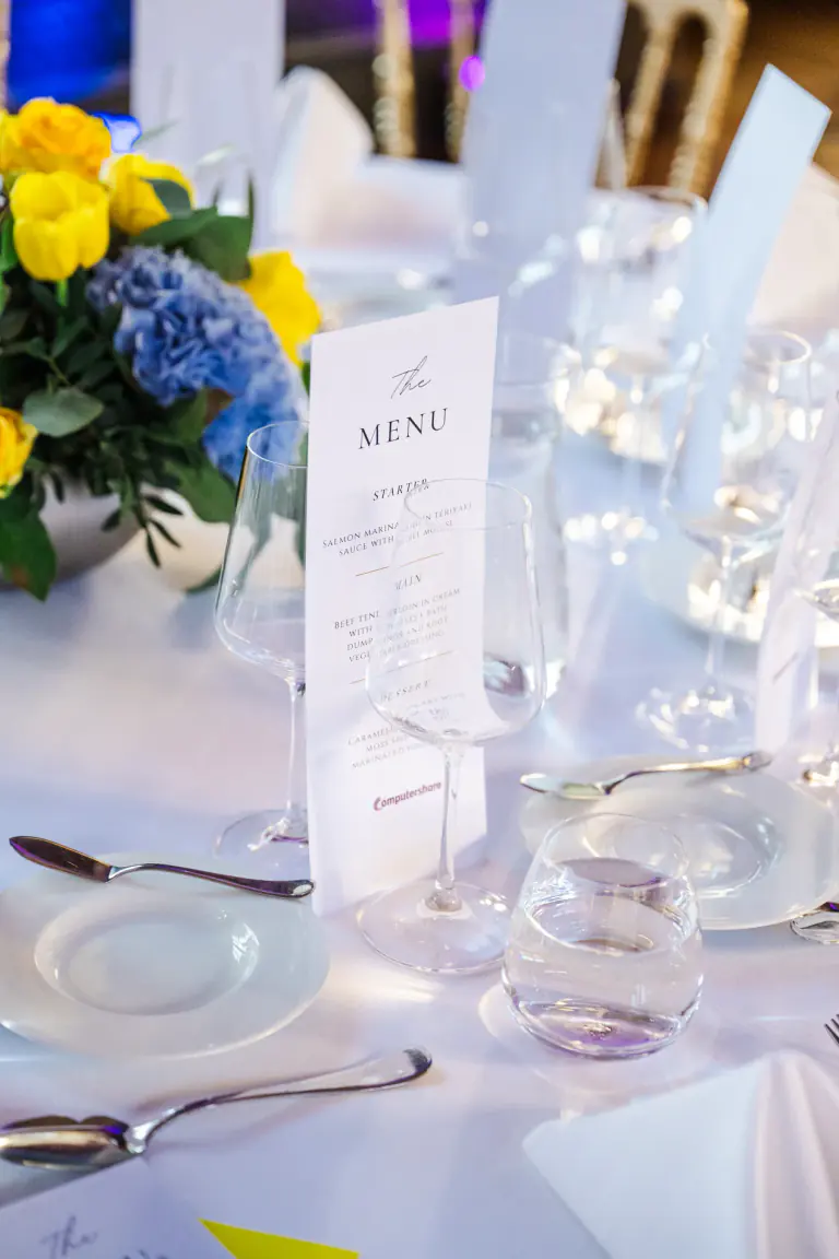 Menu, glassware and floral detail on a gala table
