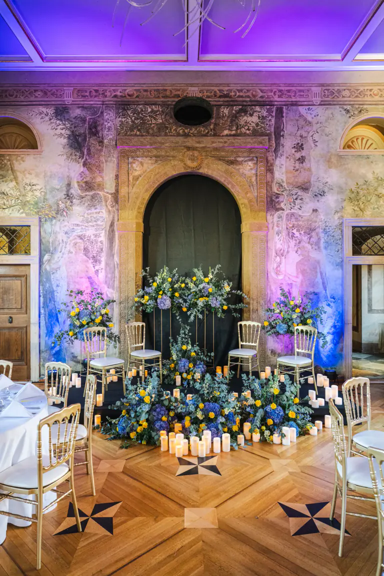 Tall floral and candle installation in a historic room