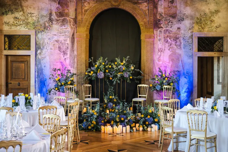 Floral installation and candlelight framing a ceremonial doorway