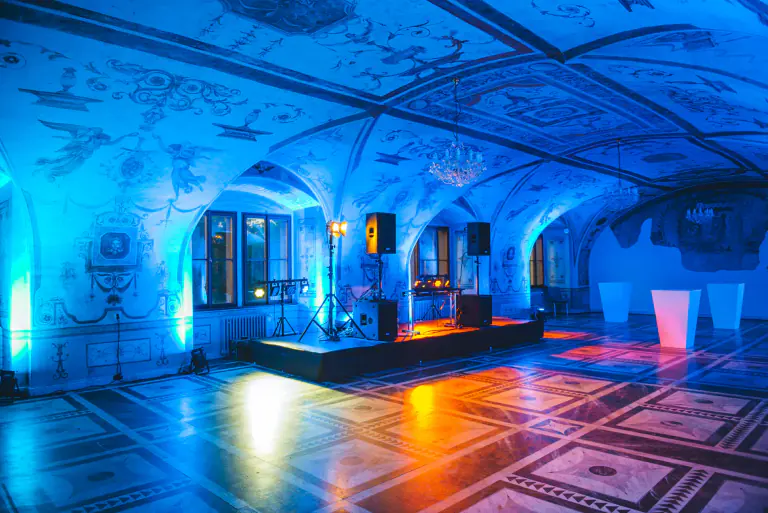 Blue lighting revealing the decorated ceiling of a historic hall