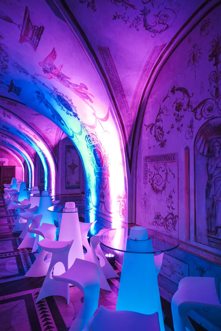 Deep indigo event lighting shaping a historic interior