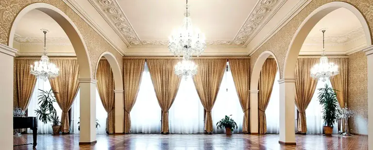 Bright empty salon with arches and chandeliers inside Kaiserstejn Palace