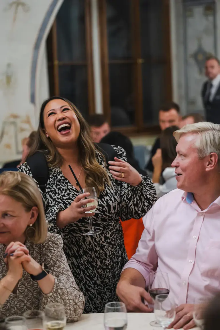 Guests smiling and talking during a seated event