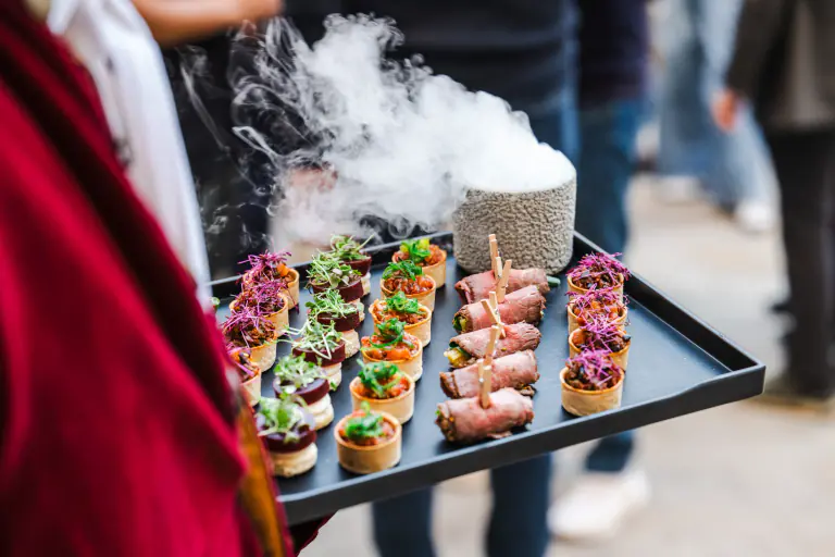 Theatrical tray of canapes presented with a veil of culinary smoke