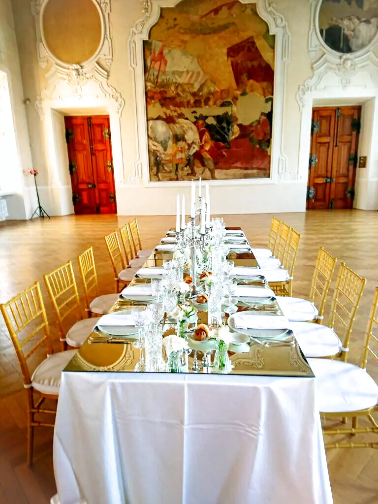 Formal dining table beneath a historic painting at Zbraslav Château