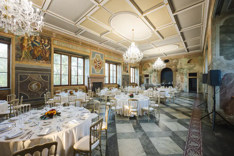 Sunlit gala dinner setting beneath the frescoes and chandeliers of Martinic Palace