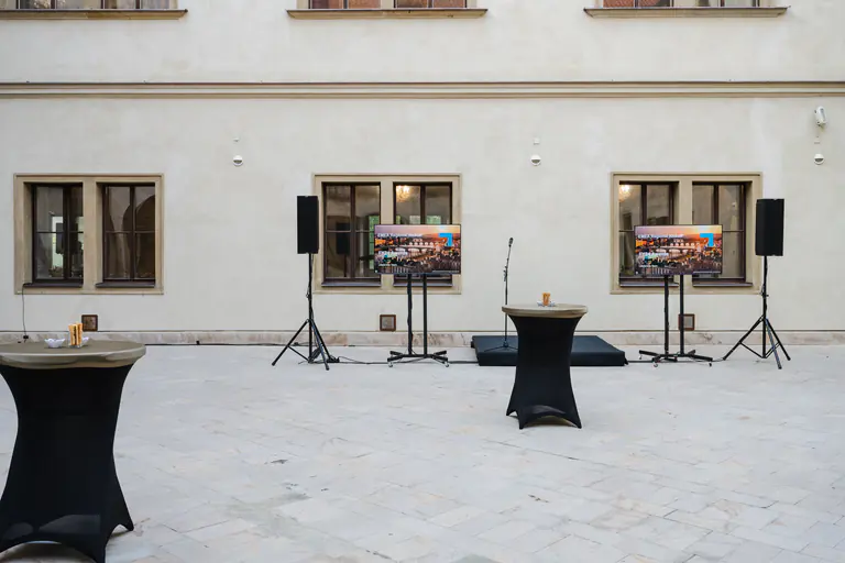 Palace courtyard prepared with presentation screens and standing tables