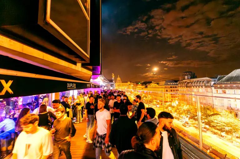 Guests gathering on the Duplex rooftop terrace above central Prague